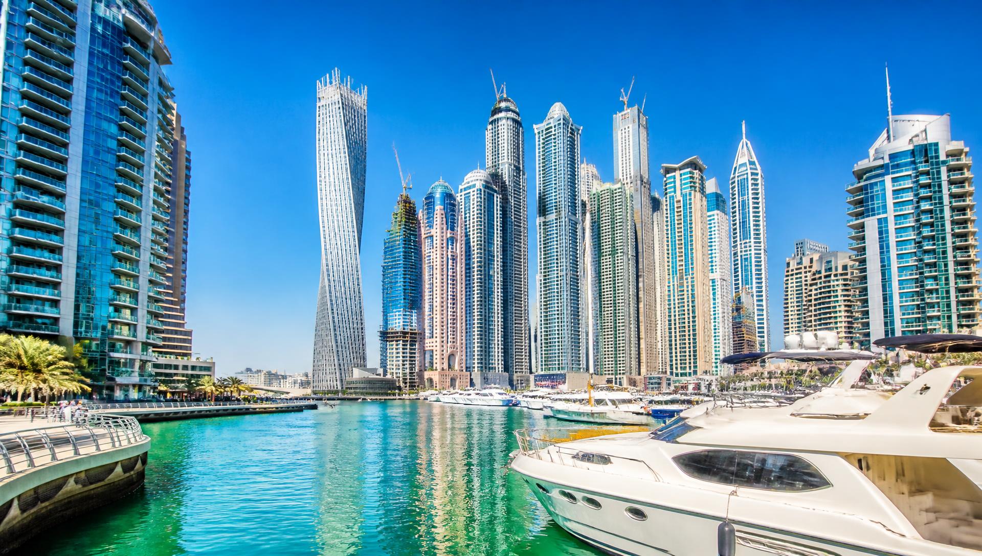 Bright daytime view of Dubai Marina with turquoise water and modern skyscrapers
