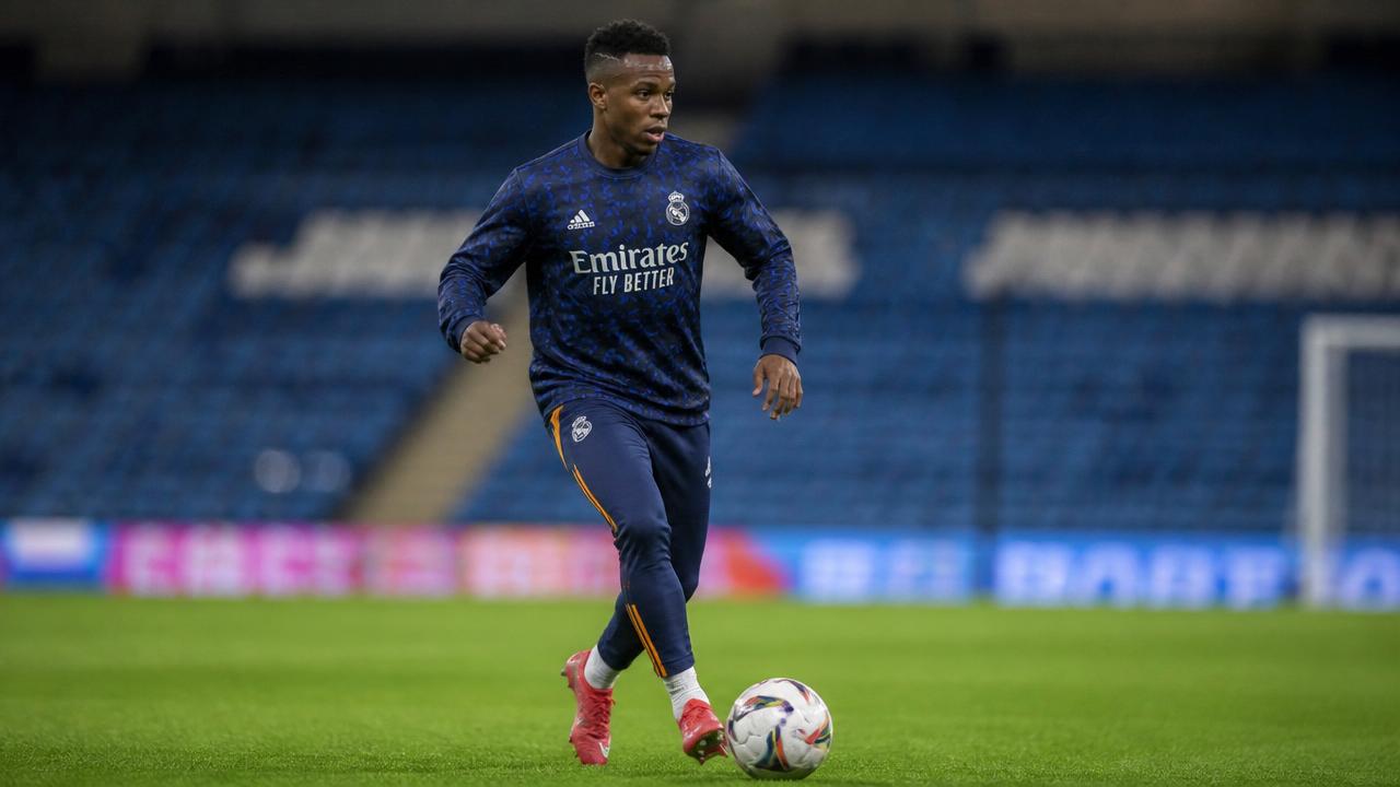 African footballer training on a European stadium pitch at sunset